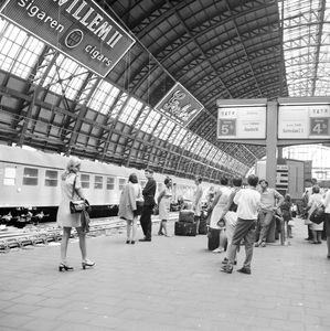 881979 Afbeelding van wachtende treinreizigers op het tweede perron van het N.S.-station Amsterdam C.S. te Amsterdam.